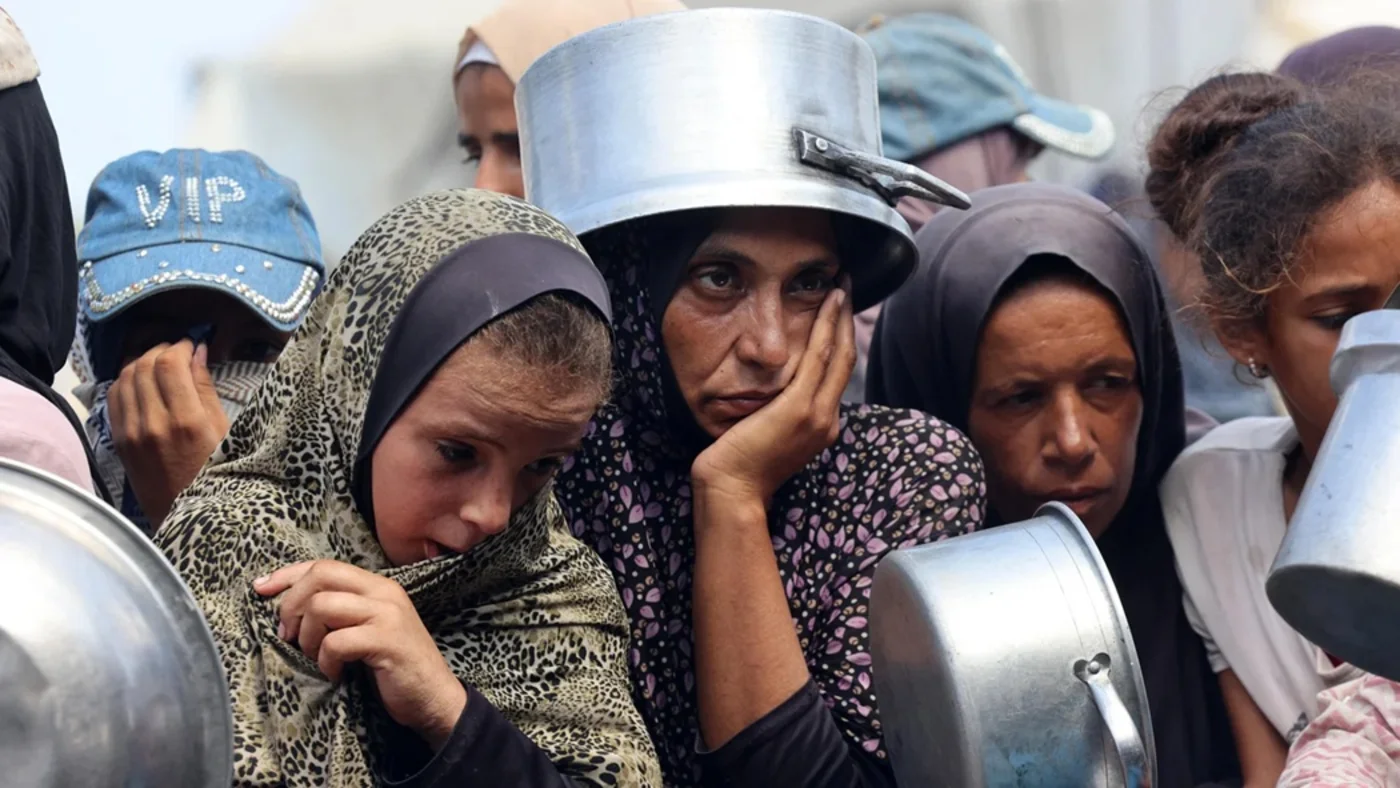 Palestinians wait to receive food from a charity kitchen in Khan Younis, south Gaza, on 21 August 2025 (AFP)