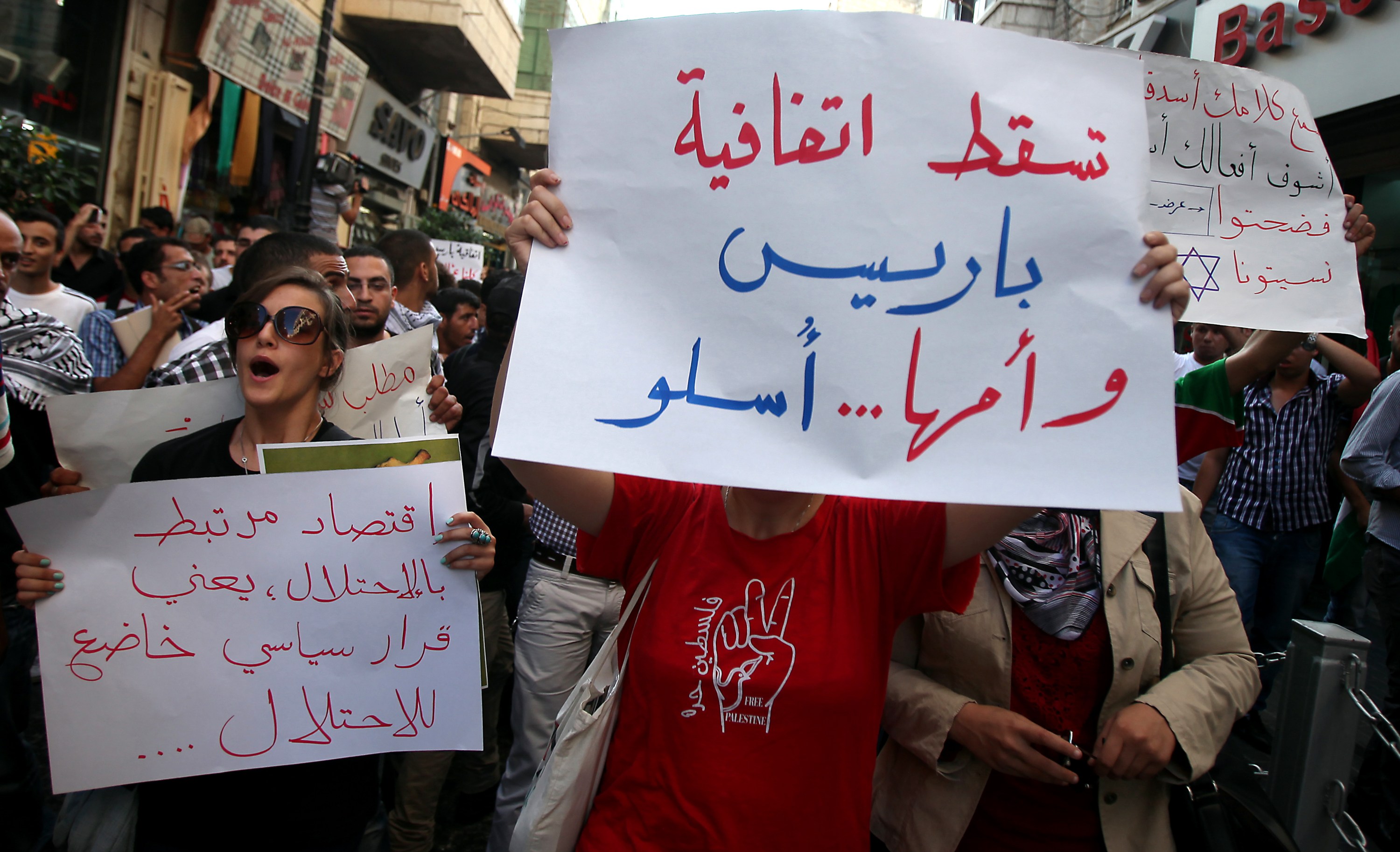 A Palestinian protester holds a placard that read in Arabic 