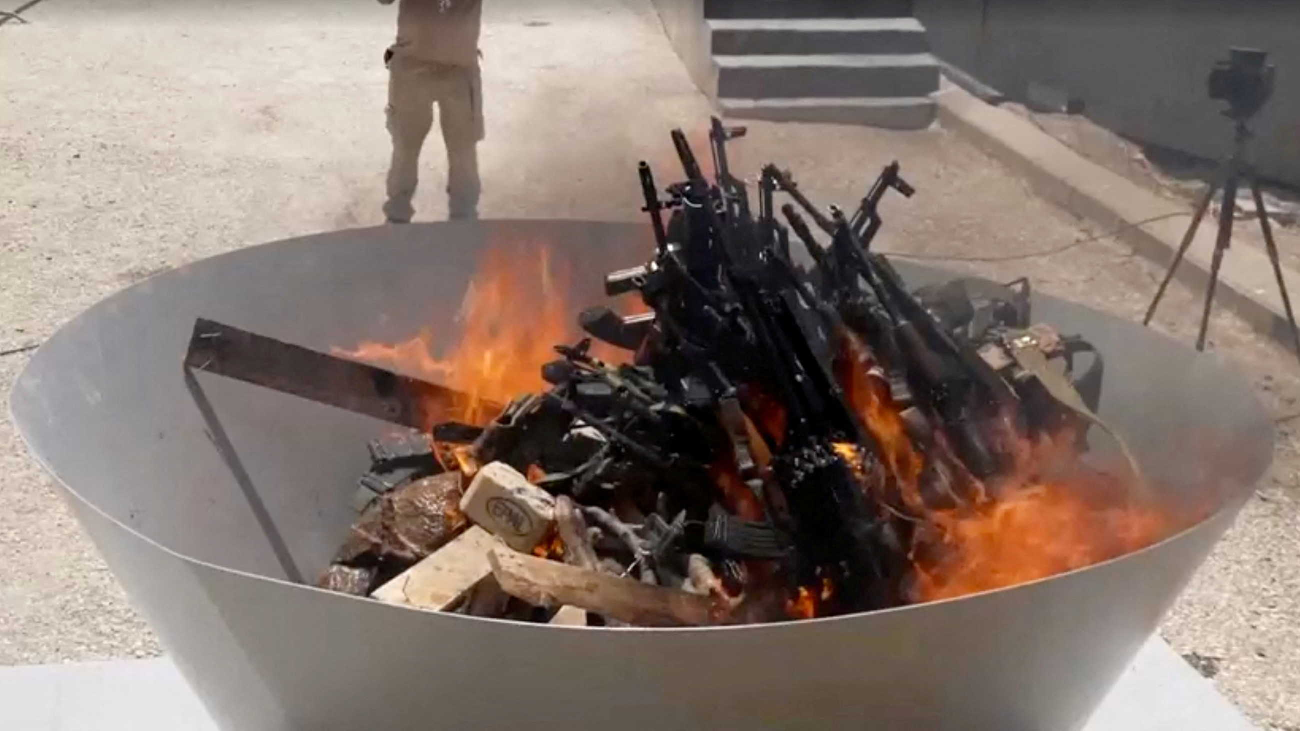 Weapons placed by PKK fighters are burnt during a disarming ceremony in Sulaymaniyah, Iraq, July 11, 2025 (screengrab/PKK/Reuters)