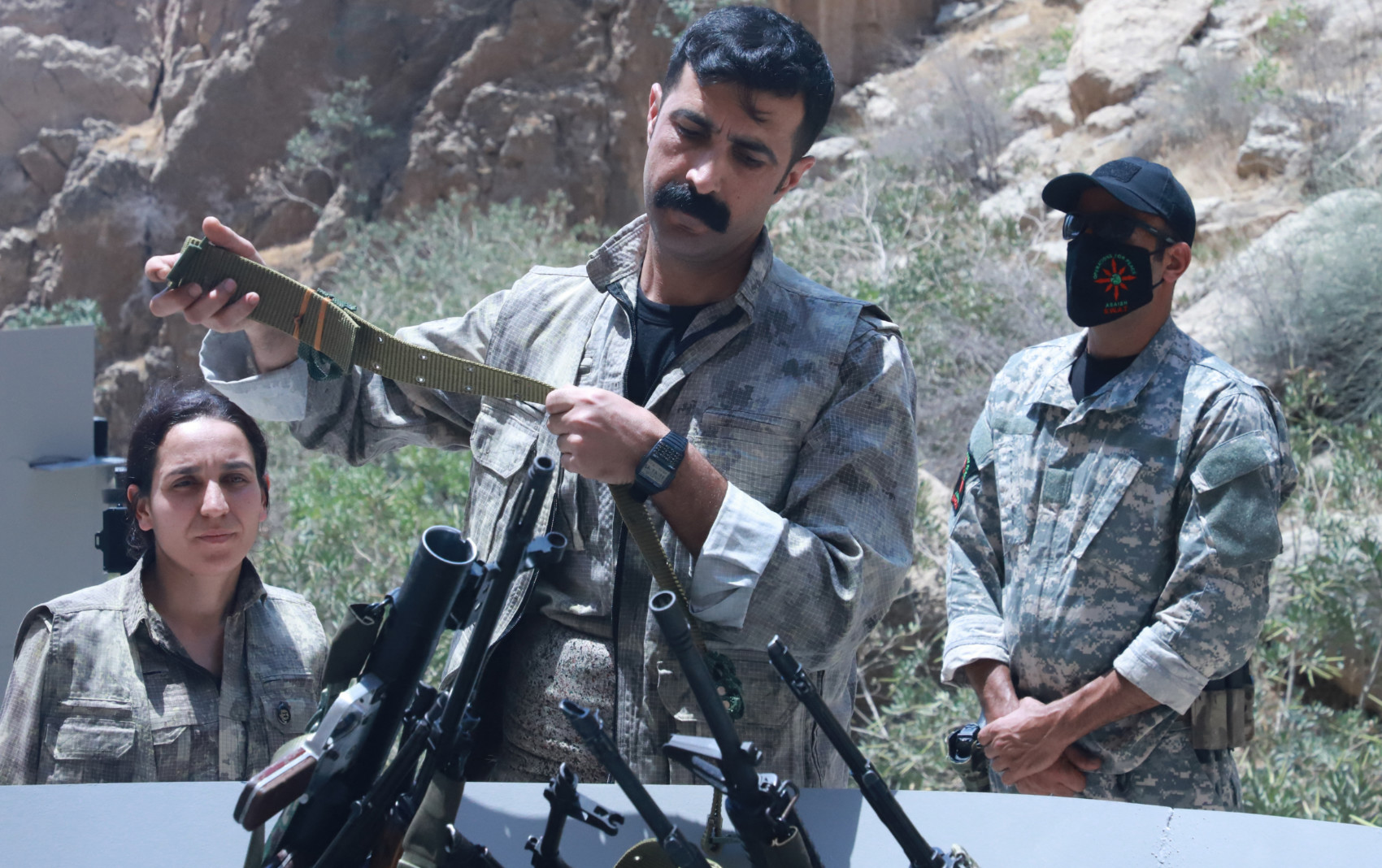 A fighter with the Kurdistan Workers' Party (PKK) puts his weapon into a pit during a ceremony in Sulaymaniyah, in Iraq's autonomous Kurdistan region, on 11 July 2025 (AFP)