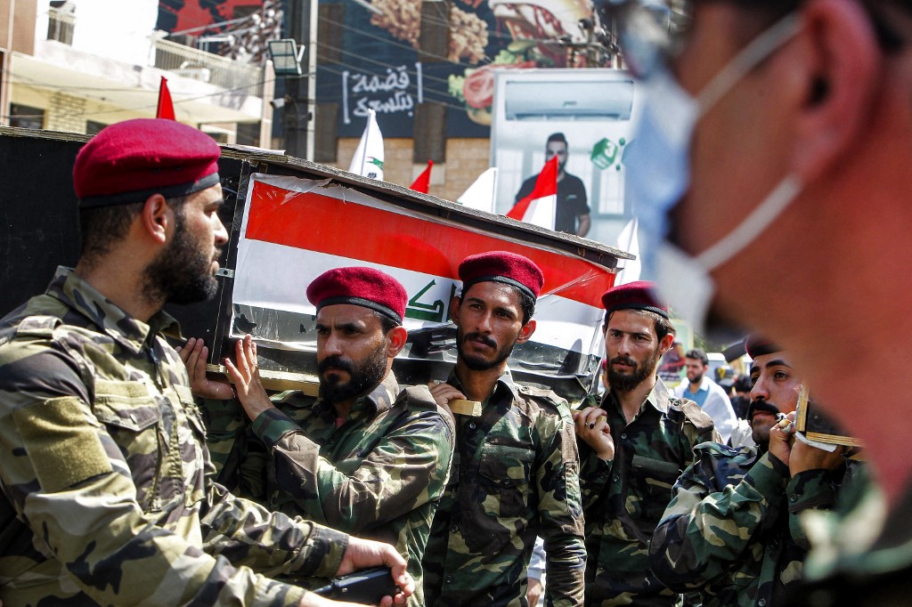 PMF forces march in a symbolic funerary parade in Baghdad on 29 June 2021, in remembrance of those killed in a US raid (AFP)
