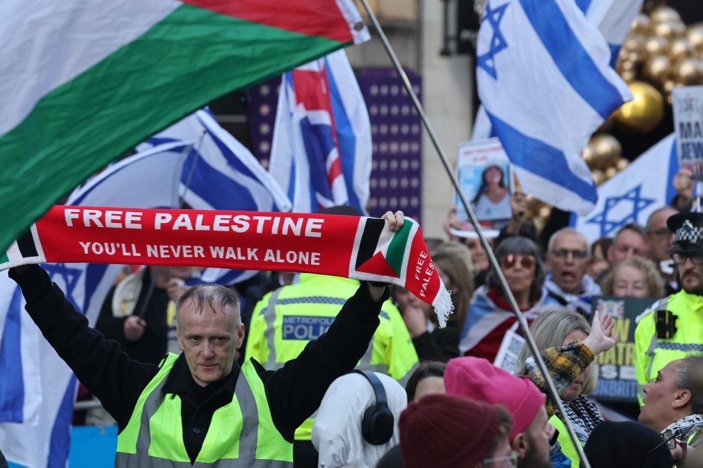 Pro-Palestinian protesters run into a group of counter-protesters waving Israeli flags in London, on 30 November 2024 (Carlos Jasso/AFP)