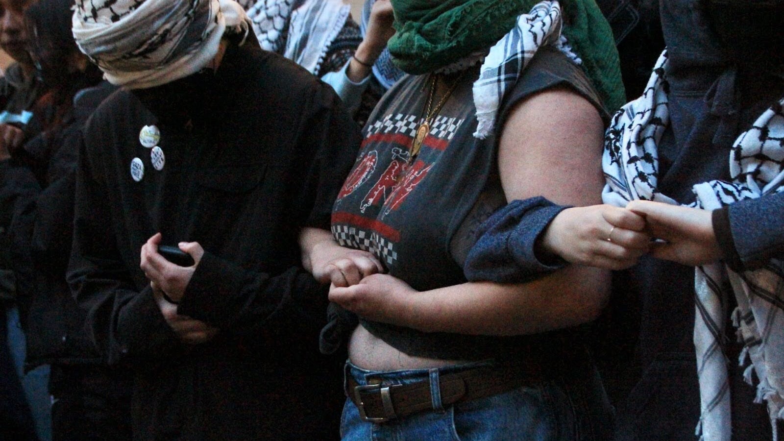 Protesting students link arms outside Hamilton Hall at Columbia University in preparation for arrests.