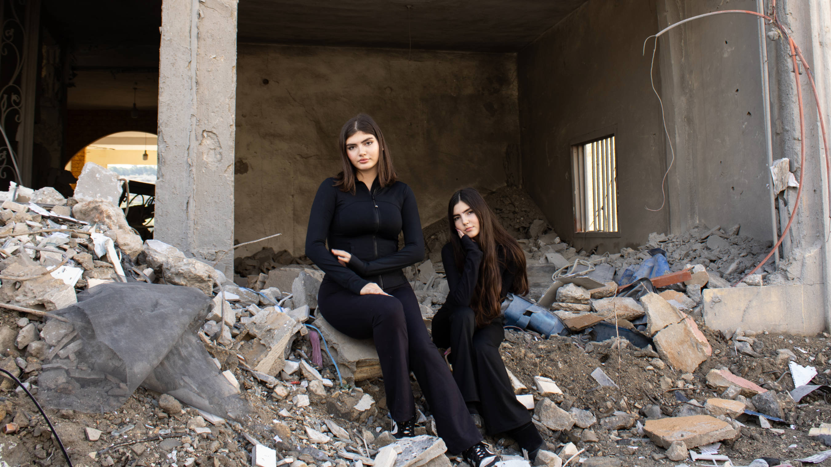 Sisters 18-year-old Amira Ghandour and 13-year-old Reine have recently returned with their family to their hometown Qana, after fleeing when Israel escalated its attacks (Hanna Davis/MEE)