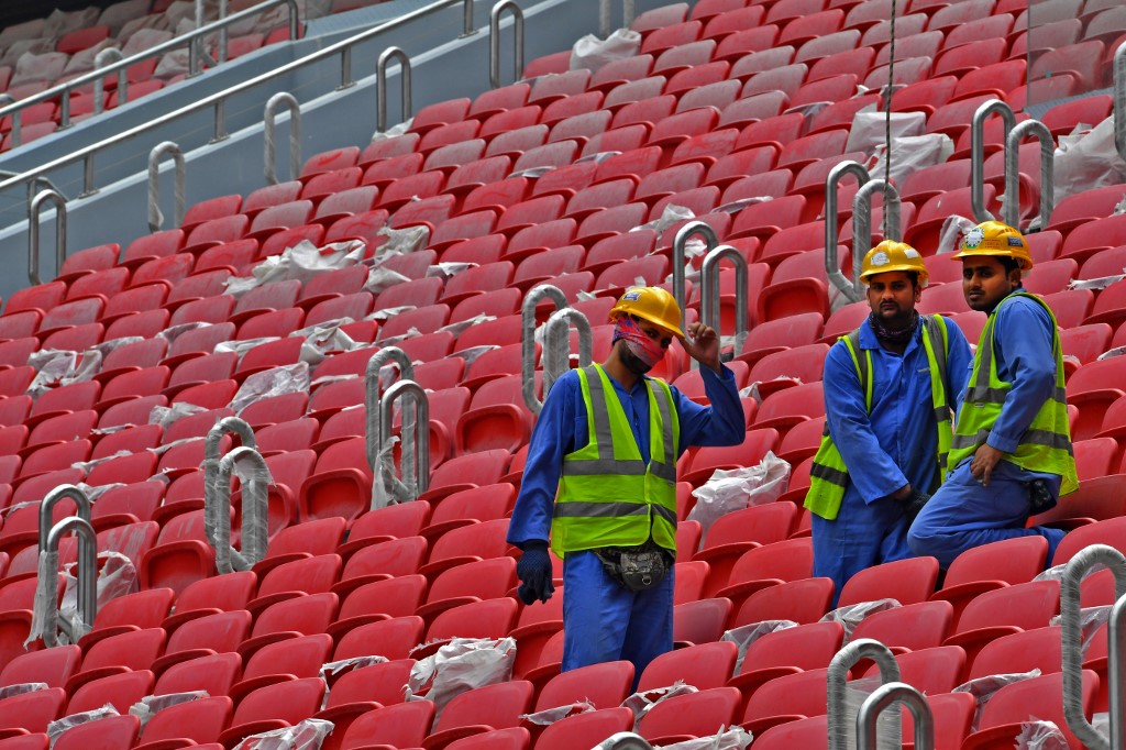 Construction workers are seen on 17 December at Qatar’s new al-Bayt Stadium, which will host matches of the World Cup in 2022 (AFP)