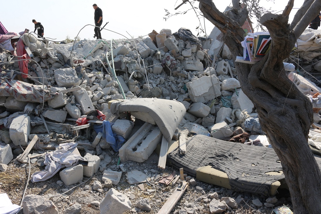 A day after the raid, residents and journalists walk through rubble where Baghdadi had been hiding (MEE/Mustafa Dahnon)