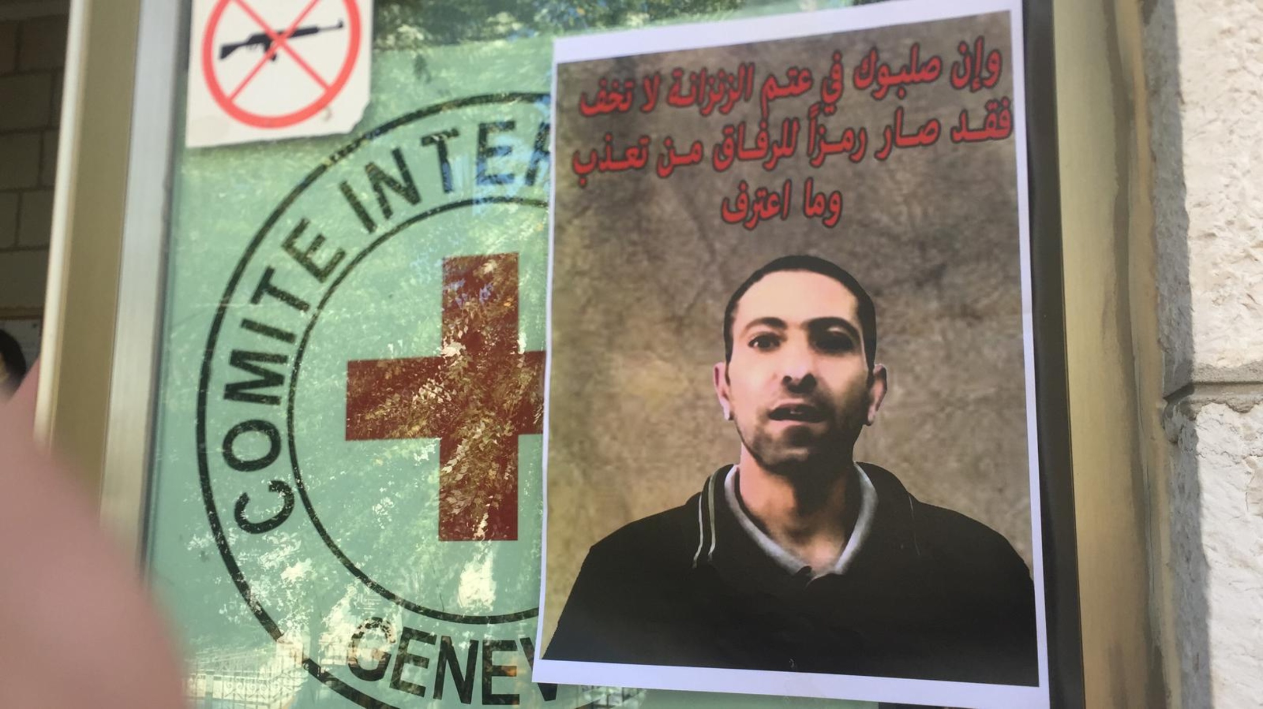 A poster showing Arbeed is taped to a window of the ICRC headquarters in the occupied West Bank city of al-Bireh (MEE/Shatha Hammad)