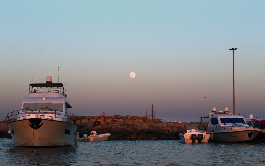 Boats are docked at a port off the coast of Sharjah in 2013 (AFP)