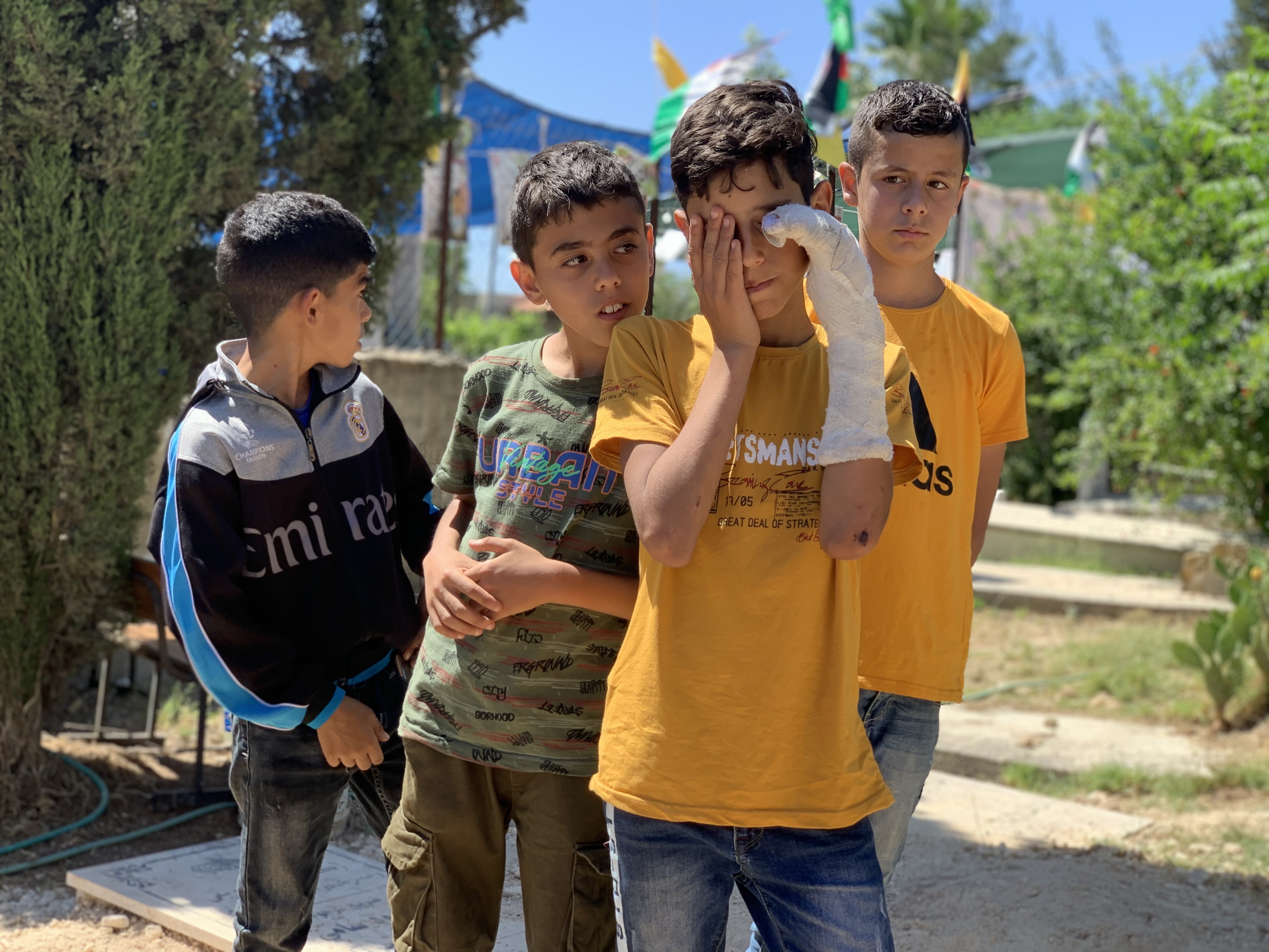 Islam Burnat's friends mourn for him at the site of his grave.