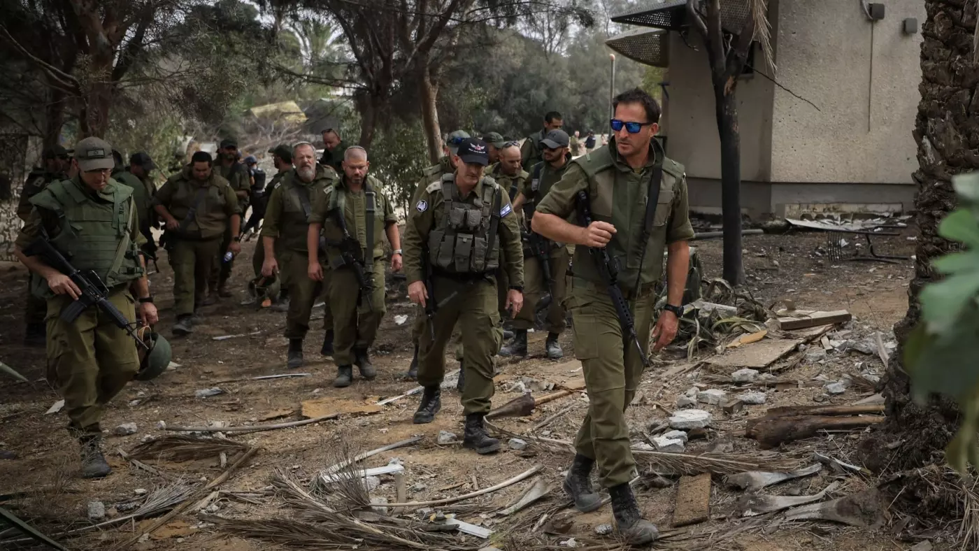 Israeli soldiers walk amongst debris in Kibbutz Kfar Aza 