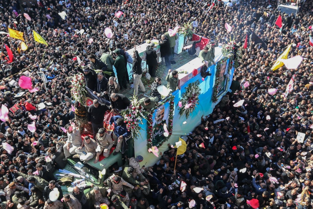 Mourners gather around a vehicle carrying the coffin of slain top general Qasem Soleimani during the final stage of funeral processions in his hometown Kerman on 7 January (AFP)