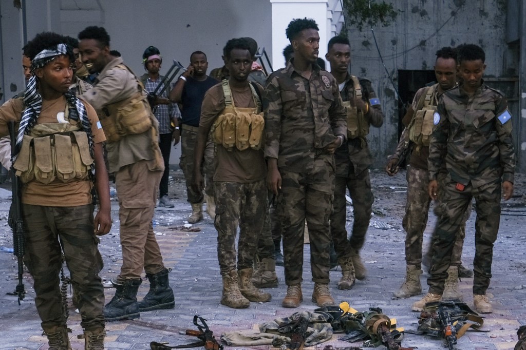 Police officers stand near the bodies of alleged al-Shabab militants killed in Mogadishu on 22 January 2023 (AFP)