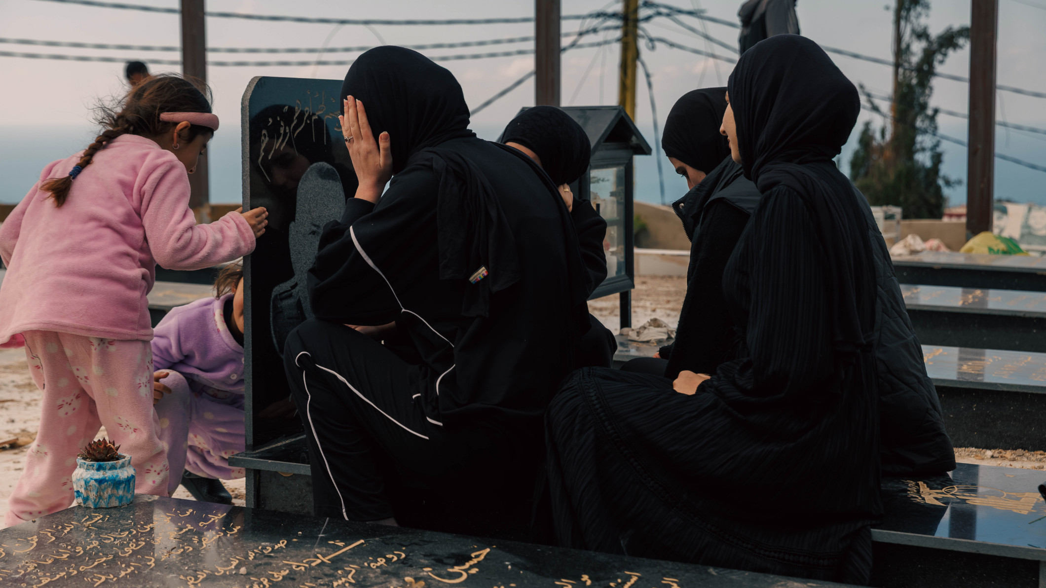 A group of young women gather in reflection at the cemetery in Majdal Zoun, southern Lebanon (Perpigna Iban Laurent/MEE)