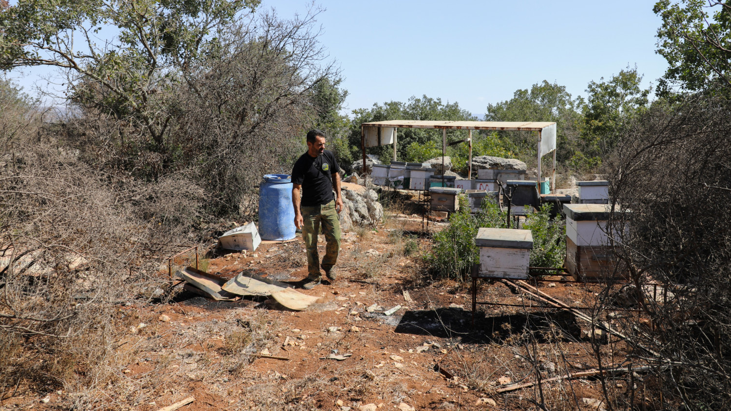 Mohammed walks on his farm in Yater, where an Israeli strike destroyed 45 beehives and killed his cows and dogs (Lea Thomas/MEE)