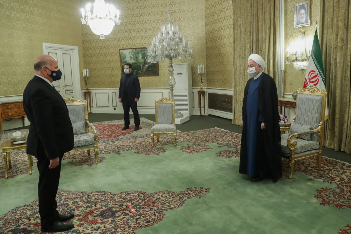 Hassan Rouhani (R) welcomes Iraqi Foreign Minister Fouad Hussein (L) 