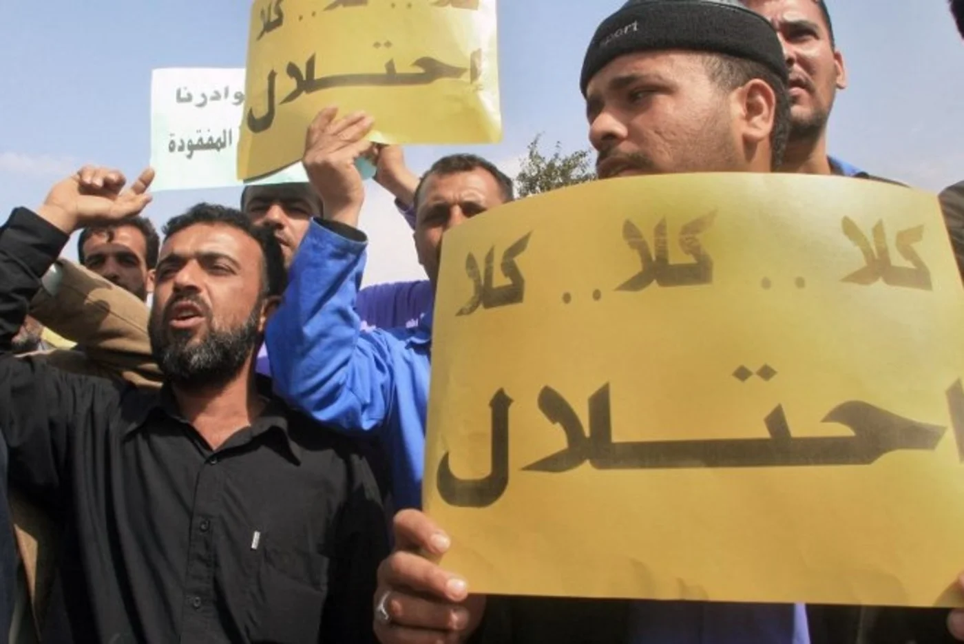 Employees of the southern Basra province energy company carry placards that read 