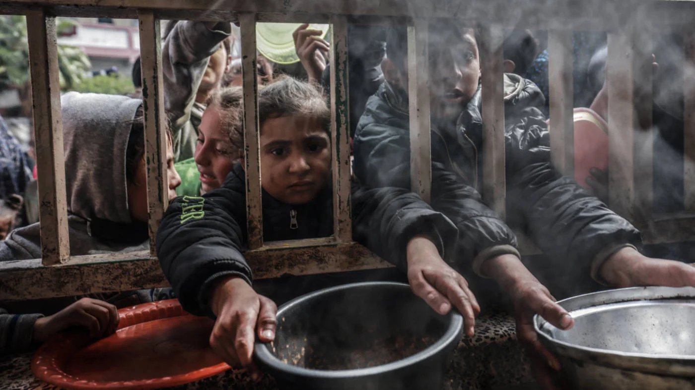 Displaced Palestinian children gather to receive food in Rafah in the southern Gaza Strip on 19 February 2024 (AFP)