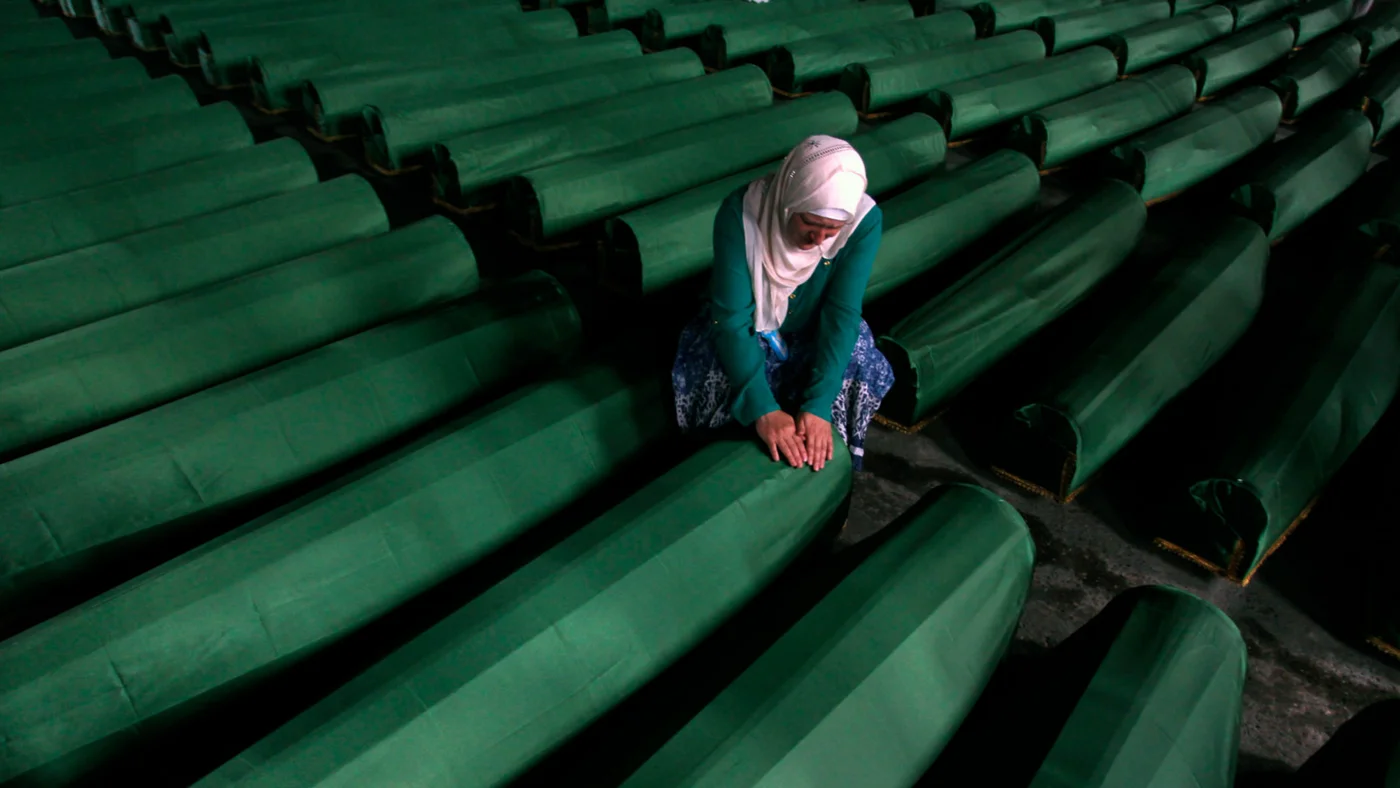 A Bosnian woman surrounded by more than 400 coffins at the  Potocari Memorial Center, near Srebrenica in July 2013 (Reuters)