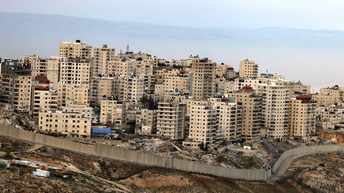 The Palestinian Shuafat refugee camp in East Jerusalem behind Israel's separation wall on 18 February 2025 (AFP)