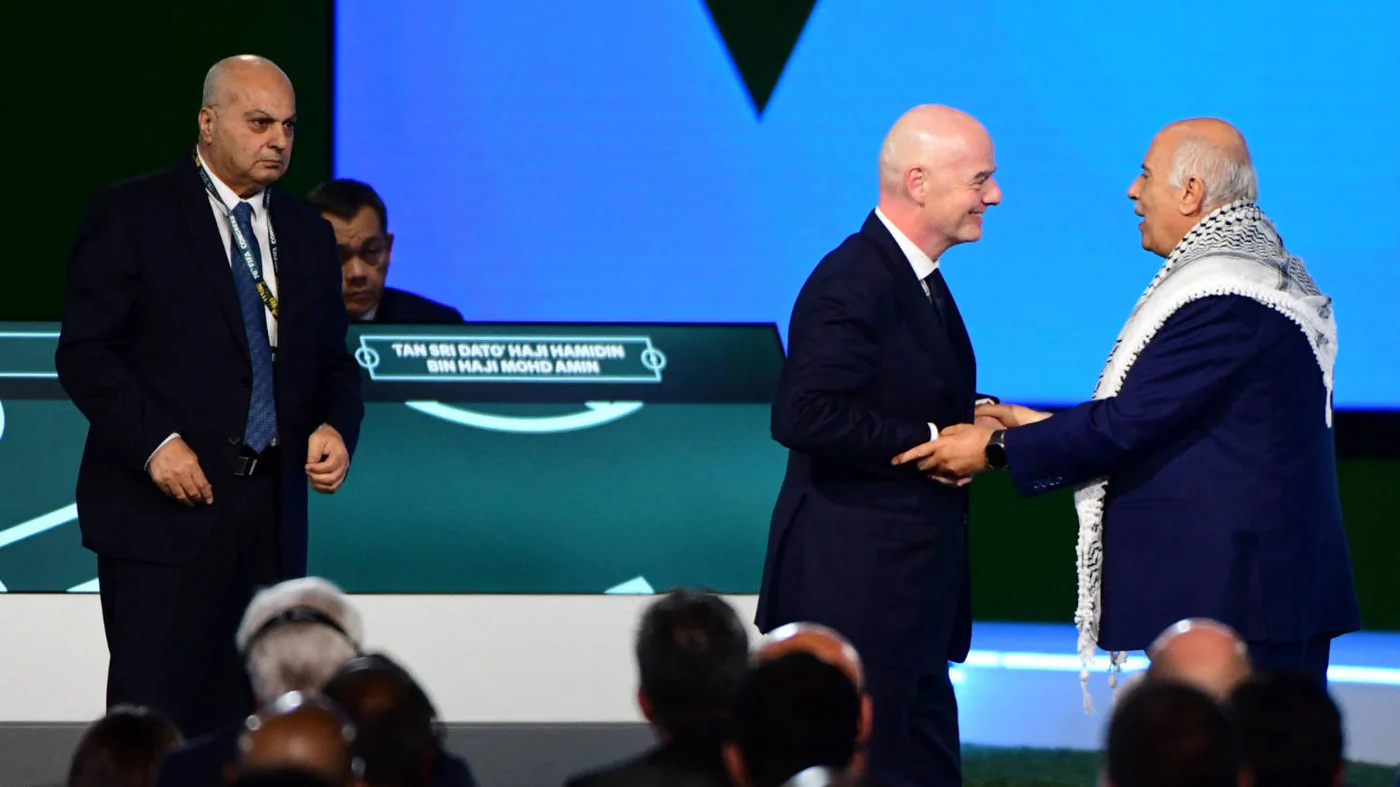 Gianni Infantino, centre, with President of the Palestine FA Jibril Rajoub, as the Vice-President of Israel FA Basim Sheikh Suliman looks on at the FIFA Congress in Vancouver on 30 April 2026 (AFP)