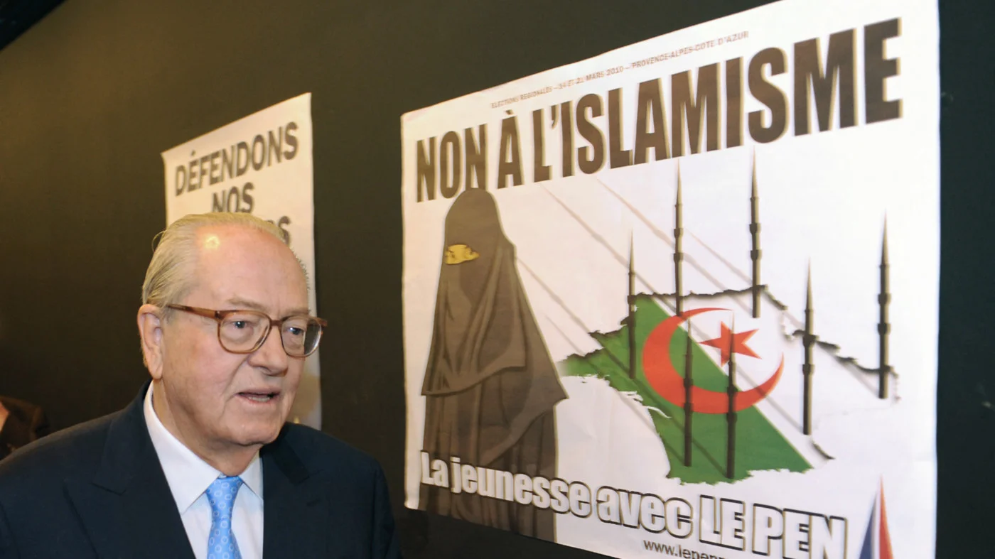 Jean-Marie Le Pen campaigns in front of an Islamophobic poster in Marseille in March 2010 (AFP)