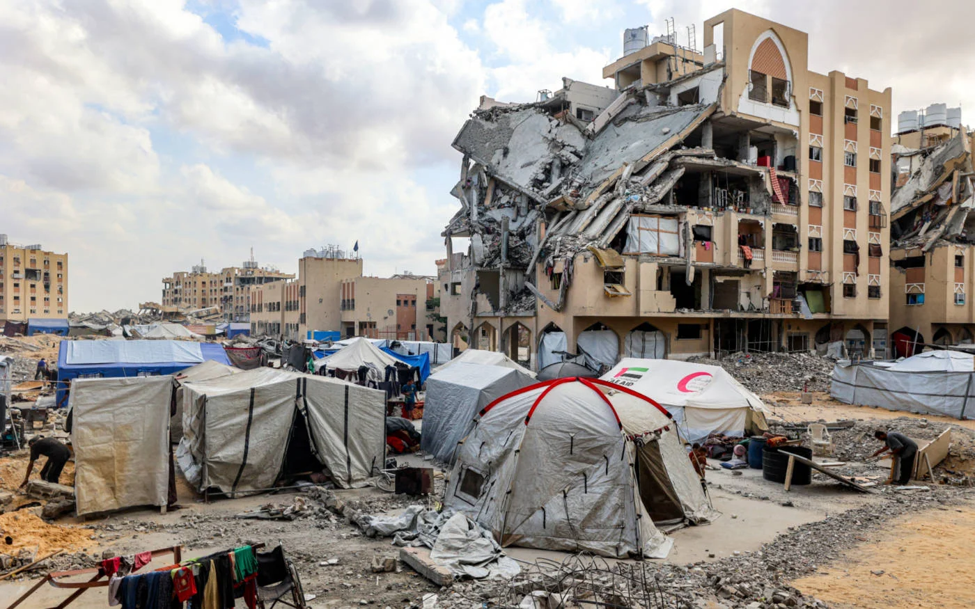 Tents shelter Palestinians in the shadow of the damaged Qatari-built Hamad City residential complex in Khan Yunis, Gaza, in September 2025 (AFP)