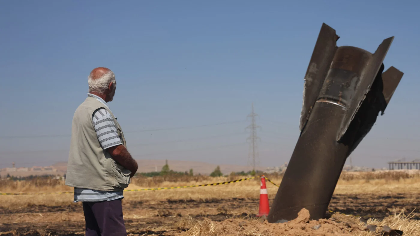 A Syrian farmer looks at an Iranian missile that fell on agricultural land in Najha, near Damascus, Syria, on 8 June 2026 (AFP)