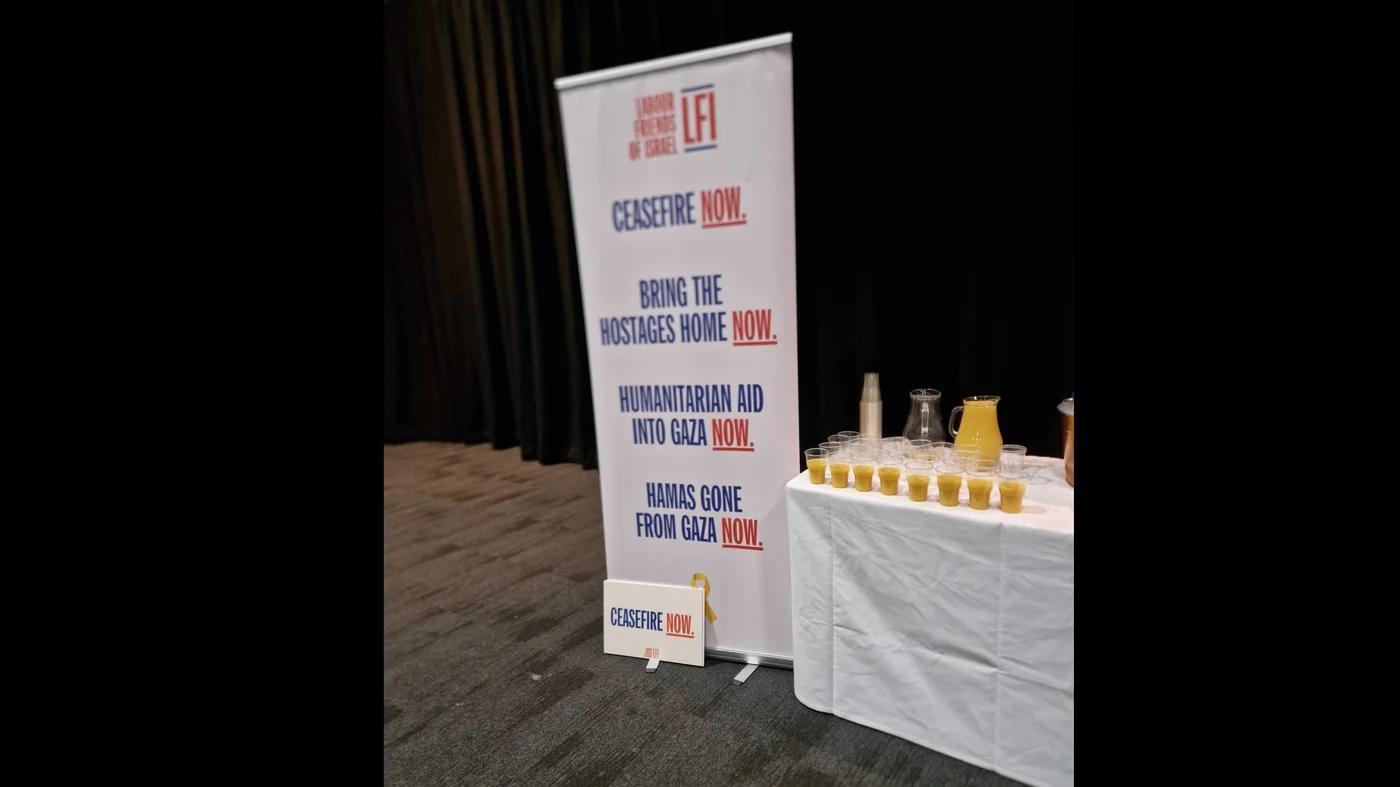 Banners at the Labour Friends for Israel event called for, among other things, aid into Gaza and a ceasefire (Imran Mulla/MEE)