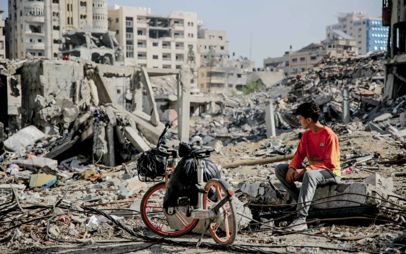 A Palestinian youth surveys the rubble of Gaza City in November 2023 (AFP)
