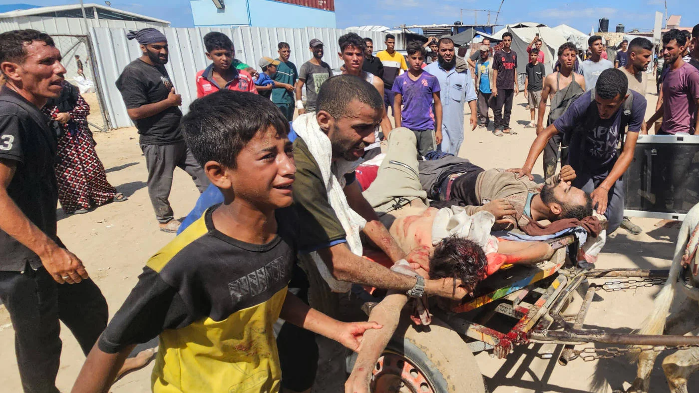 Palestinians transport victims to a Red Cross clinic in Rafah, southern Gaza, as they were shot while waiting to receive food parcels at a GHF hub on 12 July 2025 (AFP)