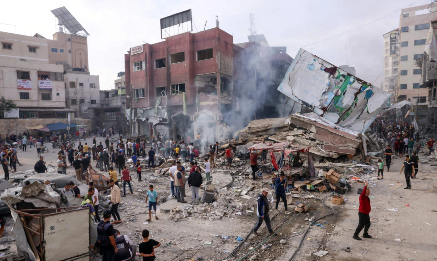 Palestinians inspect the rubble of a collapsed building in Khan Yunis in the southern Gaza Strip following overnight Israeli shelling, on 10 October 2023 (AFP)