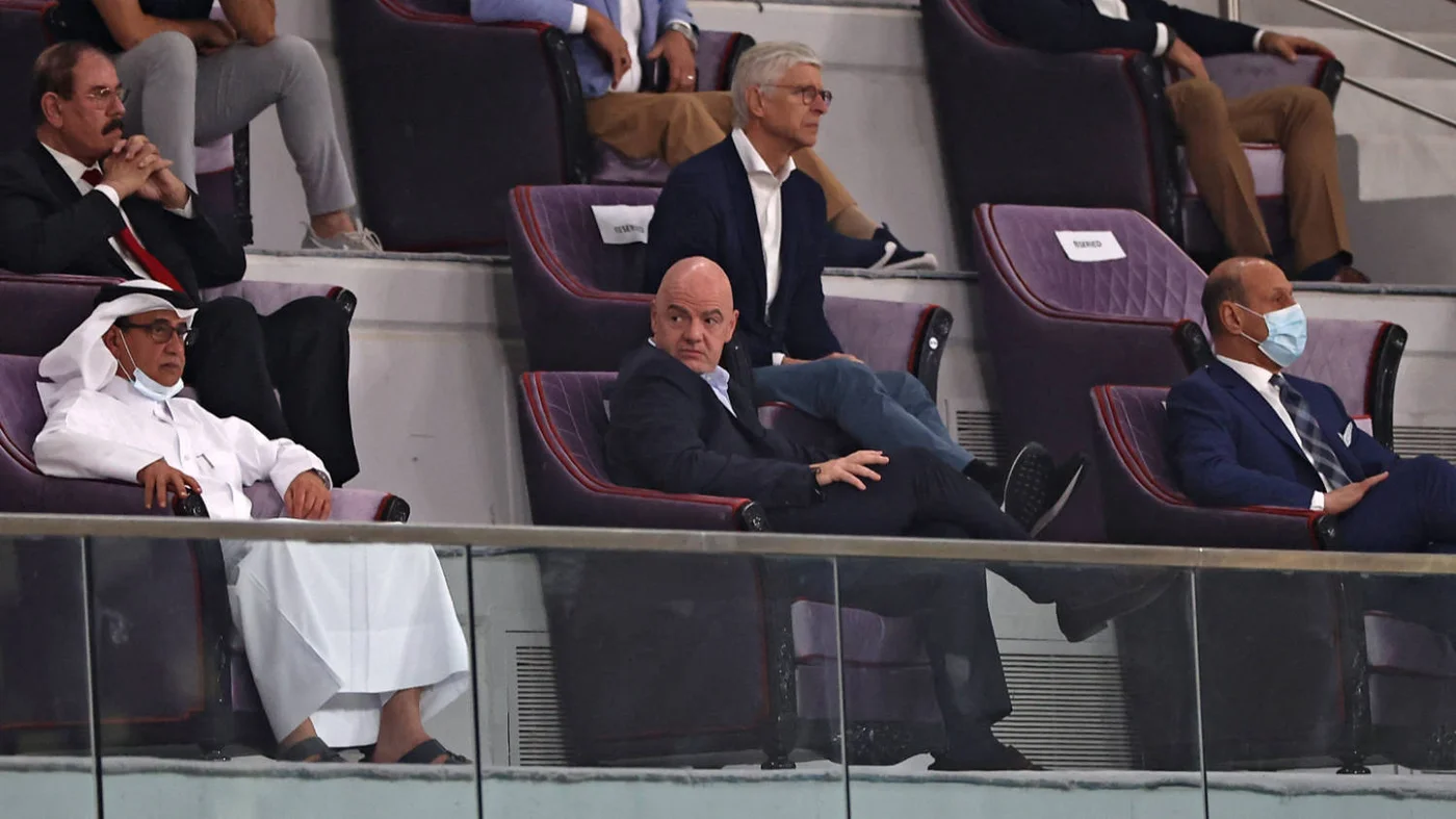 Gianni Infantino (centre) and FIFA's Chief of Global Football Development Arsene Wenger attend the 2022 World Cup Asian Qualifiers match between Iraq and Iran, in Qatar, on 7 September 2021 (AFP)