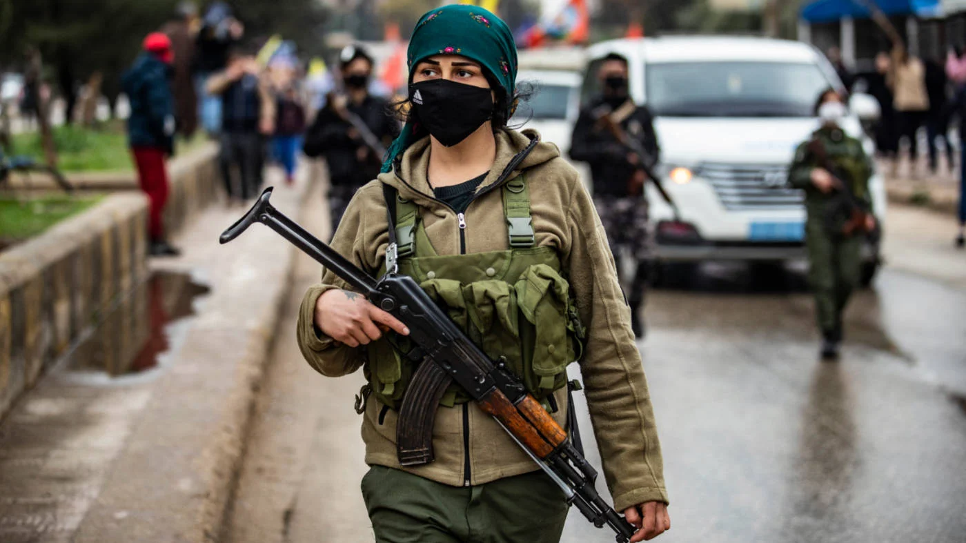 Kurdish internal security services known, as Asayish, stand guard as Syrian Kurds demonstrate in Qamishli on January 20, 2021 against the Turkish occupation of the Kurdish Syrian city of Afrin (AFP)
