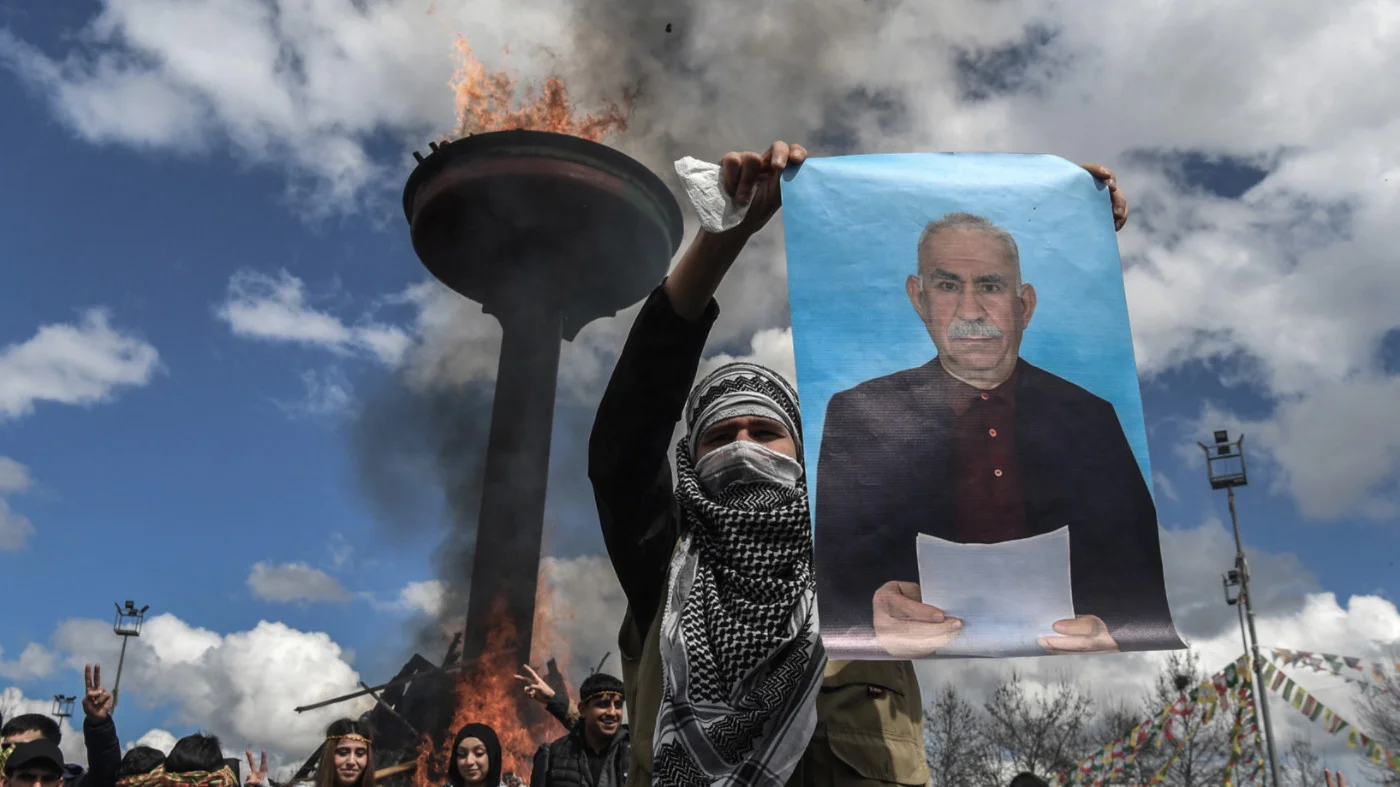 A man holds a portrait of Abdullah Ocalan, Turkish-jailed founder of the PKK during a gathering for Nowruz in Diyarbakir, south-eastern Turkey, on 21 March 2025 (AFP)
