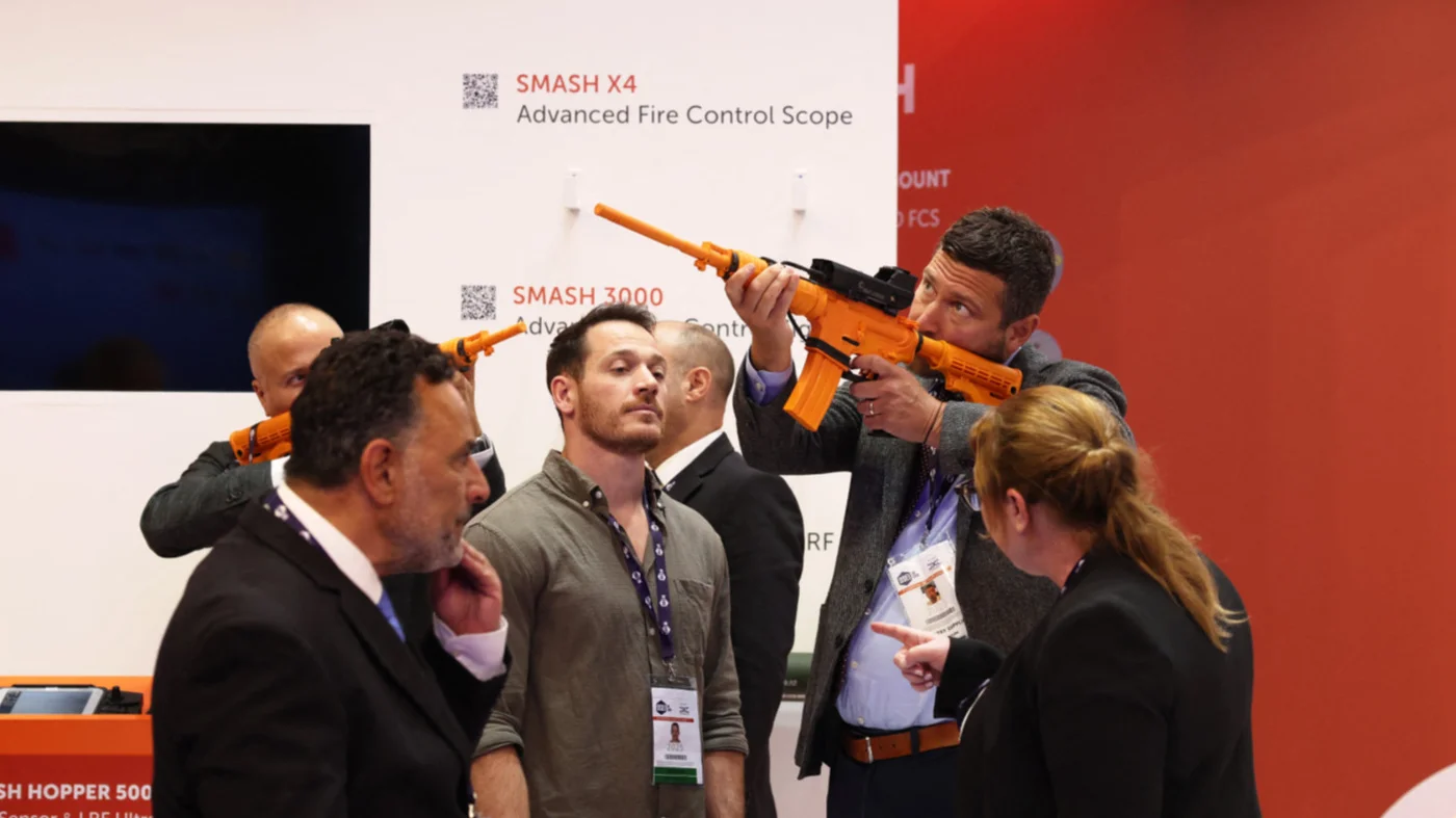 Delegates test Smash fire-control systems made by Israel-based company Sharpshooter at the DSEI fair in London in September 2025 (AFP)