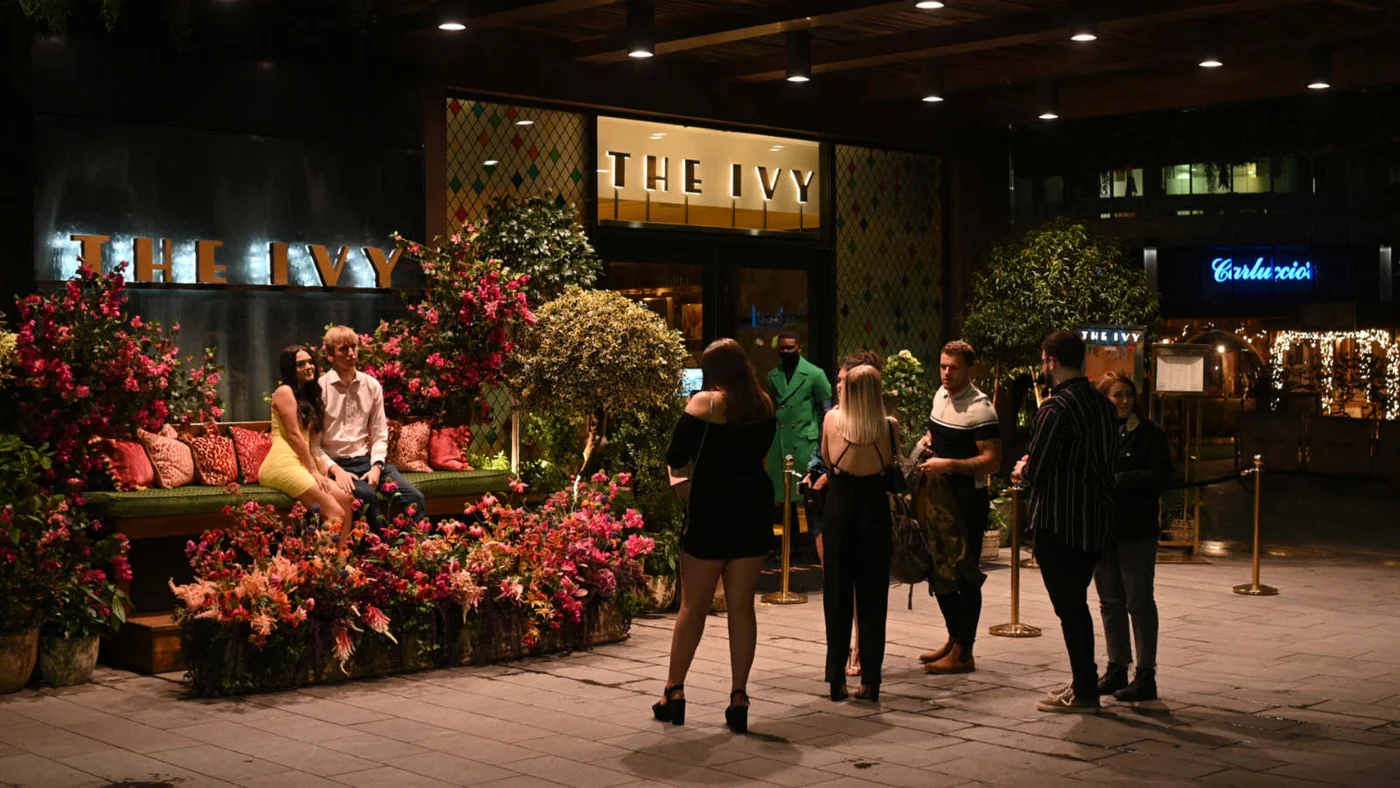 Customers wait outside The Ivy restaurant in the city centre of Manchester in October 2020 (AFP) 