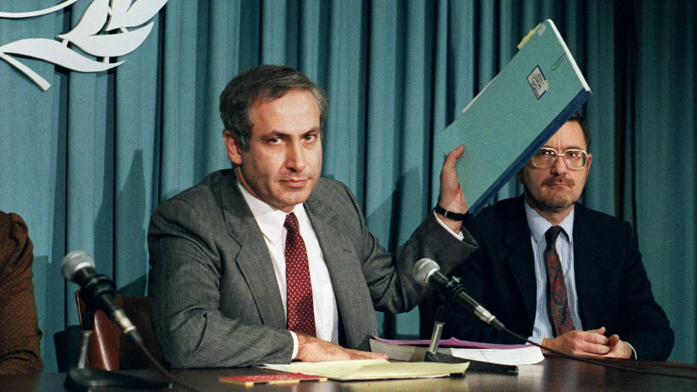Benjamin Netanyahu, then Israel’s ambassador to the UN, holds up a file on Nazi Alois Brunner at the UN in November 1987 (AFP)