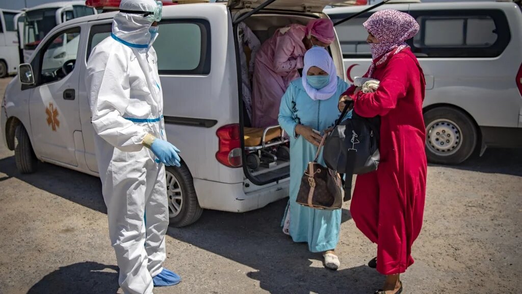 Des Marocaines, testées positives au COVID-19, sont transférées dans un centre médical (AFP)
