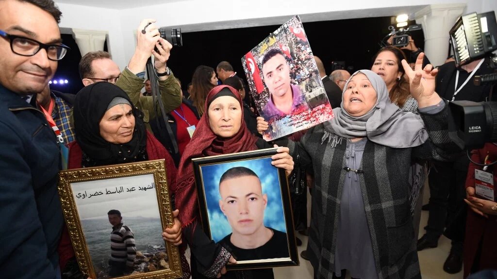 Des Tunisiennes brandissent des portraits de leurs fils à l’occasion d’une audition de l’Instance vérité et dignité, le 17 novembre 2016 (AFP/Fethi Belaïd)