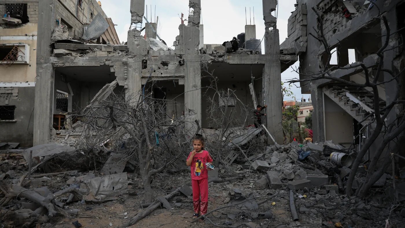A child stands in the wreckage of her neighbourhood in the Gaza Strip following Israel's military bombing campaign in May 2021. (MEE/Mohammed al-Hajjar)