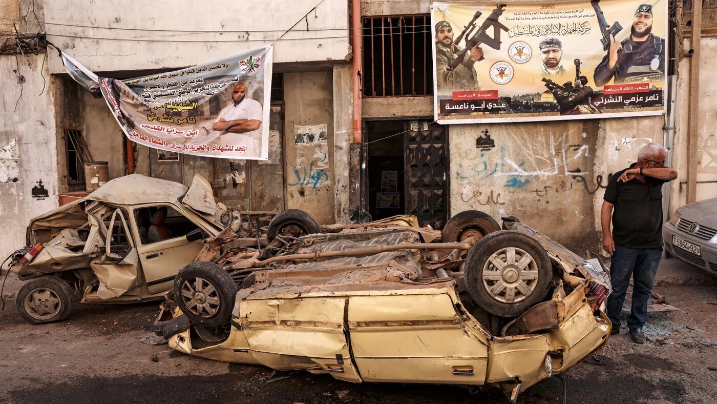 A man stands next to wrecked cars in the aftermath of a military operation in Jenin refugee camp in the occupied West Bank on July 5, 2023 (AFP)
