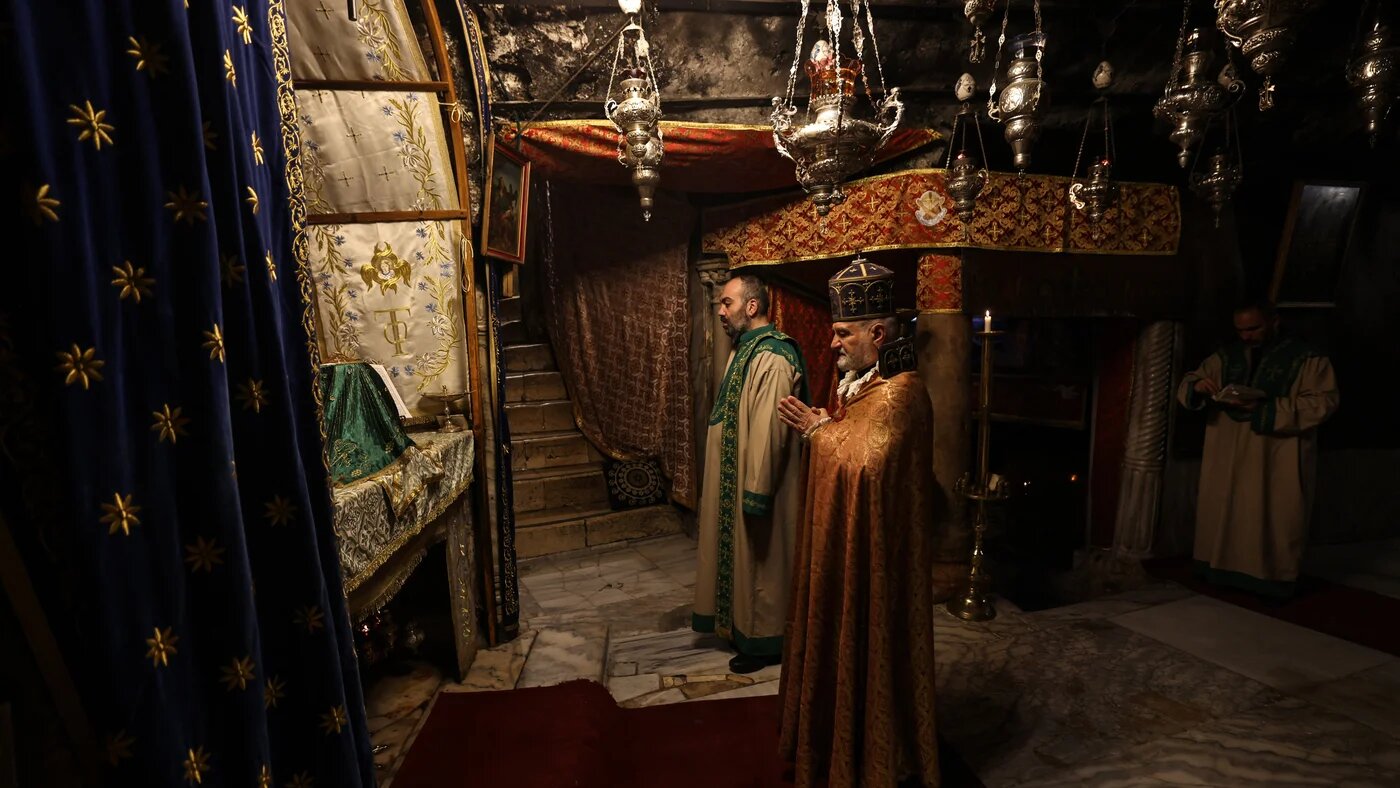 Members of the clergy pray inside the Grotto, believed to be the birthplace of Jesus Christ, in the Church of the Nativity in Bethlehem