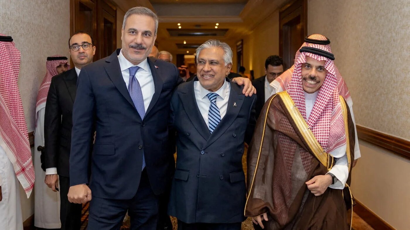 Turkish Foreign Minister Hakan Fidan, Pakistan’s Deputy Prime Minister and Foreign Minister Ishaq Dar and Saudi Foreign Minister Prince Faisal bin Farhan stand together after a meeting of the Mecca defence pact’s committee in Riyadh on 5 October 2026 (Turkish Foreign Ministry/Reuters)