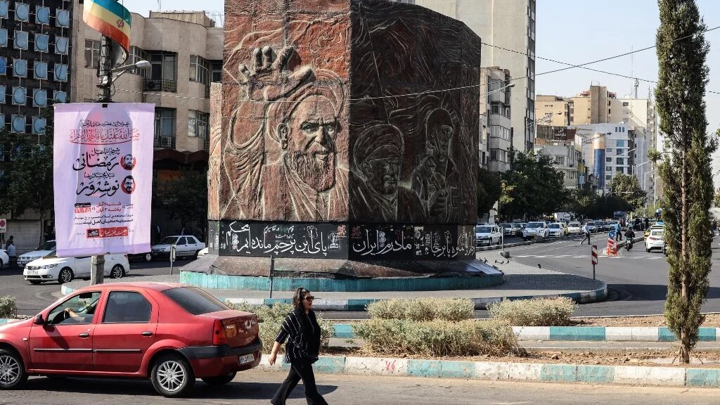 A woman walks through traffic while crossing Enghelab Square in Tehran on 26 October 2026. (AFP)