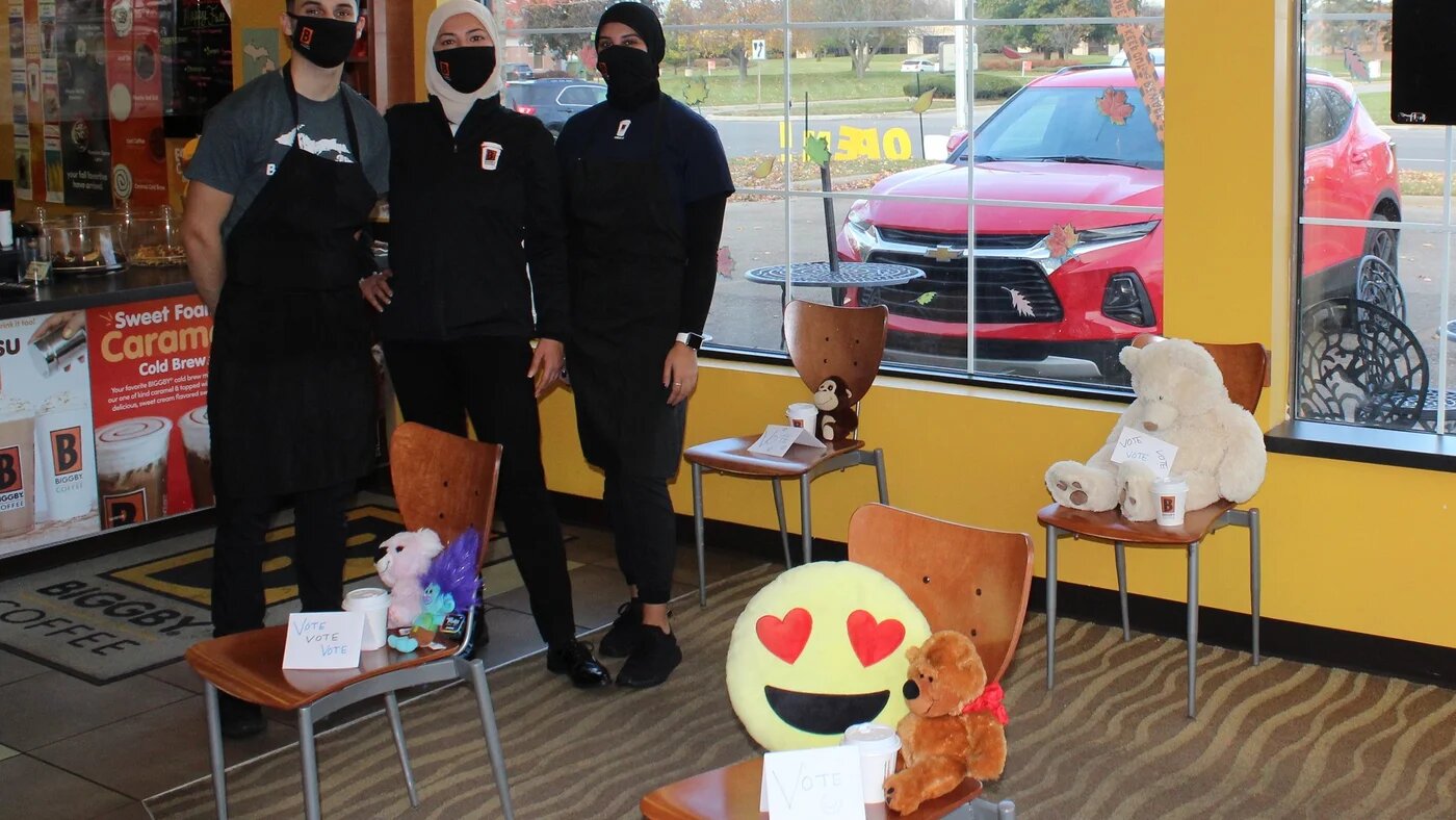 Killoud Dabaja (au centre) de Dearborn tente de créer un « espace heureux » pour la communauté de son café (MEE/Ali Harb)