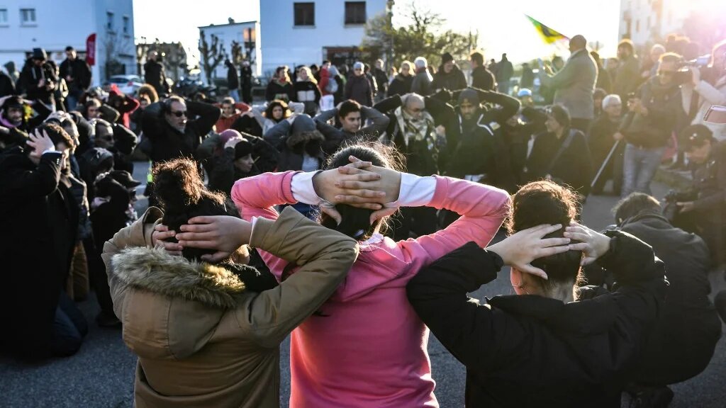 Des jeunes reconstituent une interpellation lors d’une manifestation à Mantes-la-Jolie, le 12 décembre 2018, en soutien aux lycéens interpellés en banlieue parisienne. (AFP/Alain Jocard)