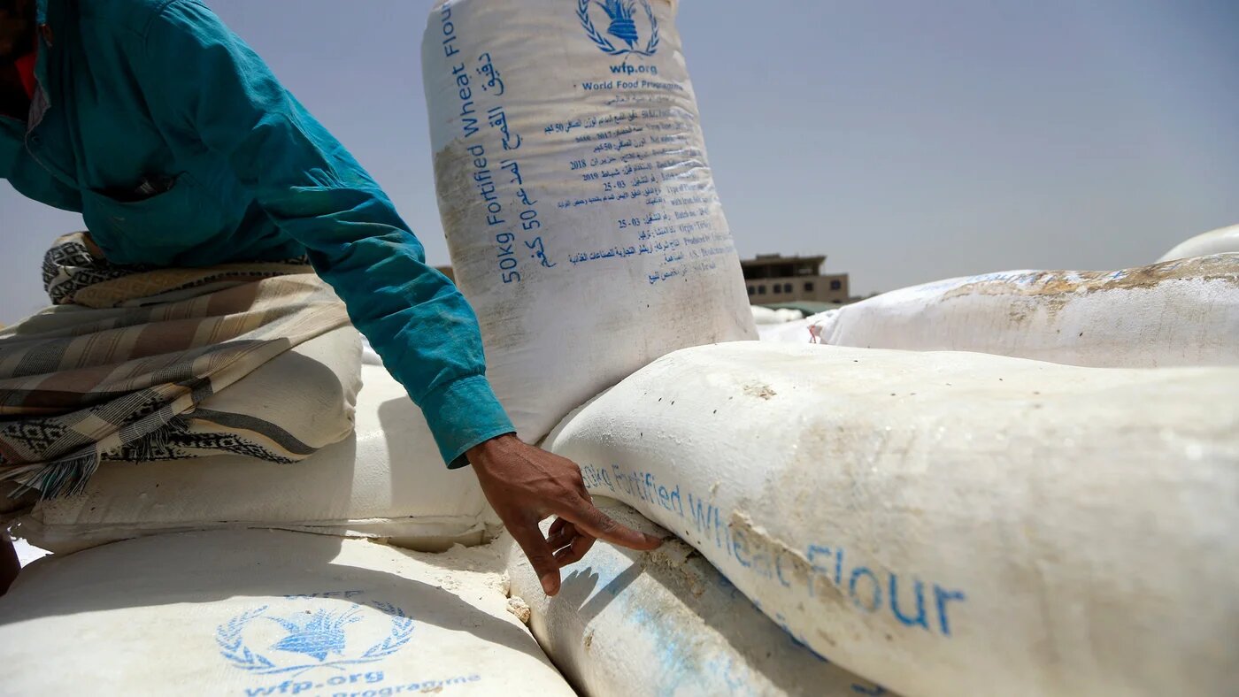 A Yemeni points to a flour bag from the World Food Organisation in the Yemeni capital Sanaa on 23 June 2019 (AFP)