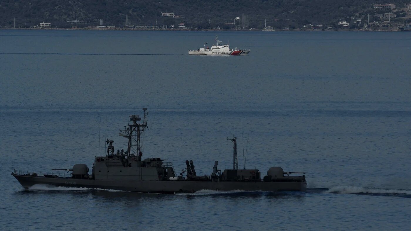 A Turkish military ship passes a coastgard patrol boat near the island of Lesbos (AFP)