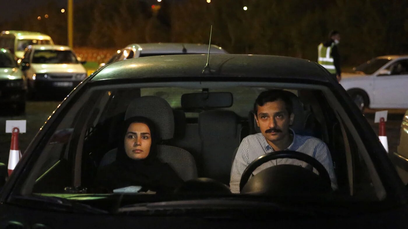 Iranians sitting in their vehicles attend a drive-in religious ceremony