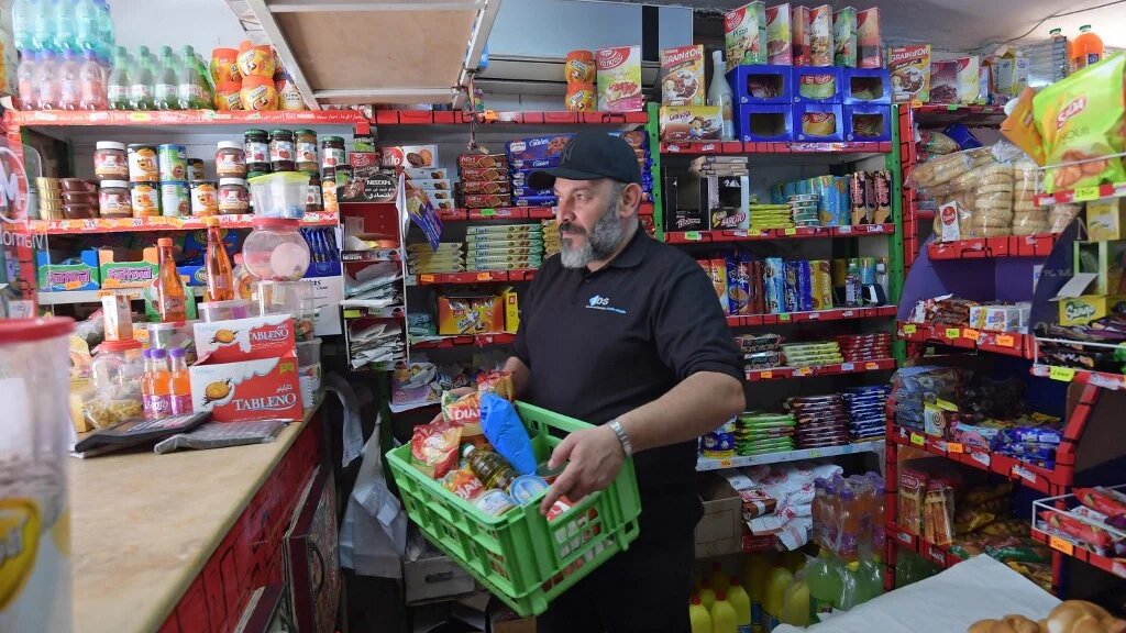 Un employé tunisien d’une épicerie prépare des rations d’aide alimentaire pour les plus démunis, à Tunis le 8 mai 2020 (AFP)